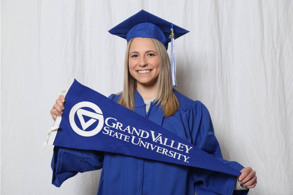 A future alumna poses with GVSU flag at GradFest